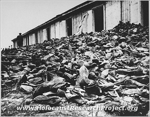 A Soviet soldier walks through a mound of victims' shoes piled outside a warehouse in Majdanek soon after the liberation
